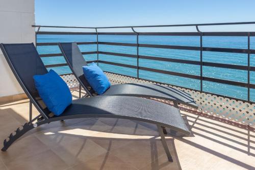 una silla en el balcón con vistas al océano en Apartamentos Mediterraneo Front en Marbella