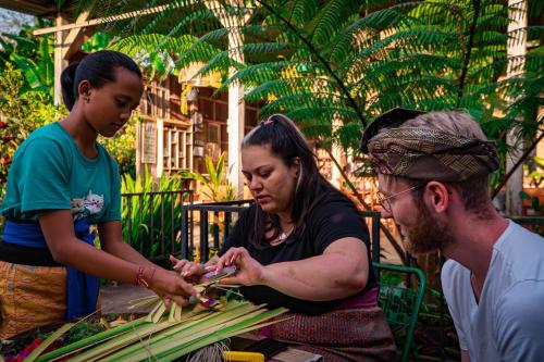 a man and woman cutting up vegetables on a table at Kebun Kita Ecolodge By Bali Cabin in Padangan