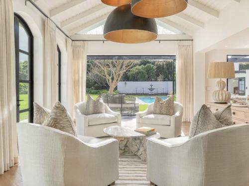 a living room with white chairs and a table at Russet Rise, Adults Only in Cape Town