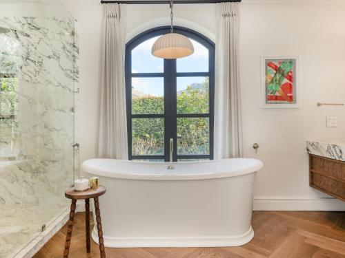 a bath tub in a bathroom with a window at Russet Rise, Adults Only in Cape Town