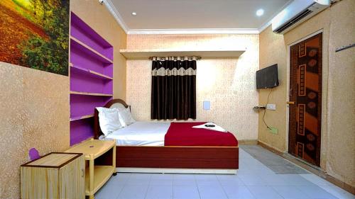 a bedroom with a bed and a desk and a tv at Grand D Gala , Dharmapuri in Dharmapuri