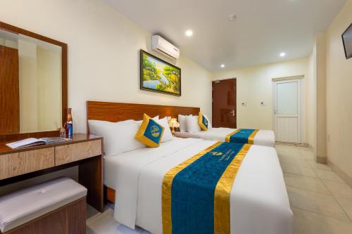 a hotel room with two beds and a mirror at Catba Cannon Fort Hotel & Spa in Cat Ba