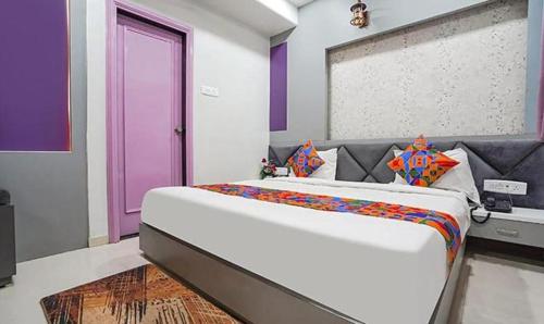 a bedroom with a large bed with a purple door at FabHotel Imperial Suites in Nagpur