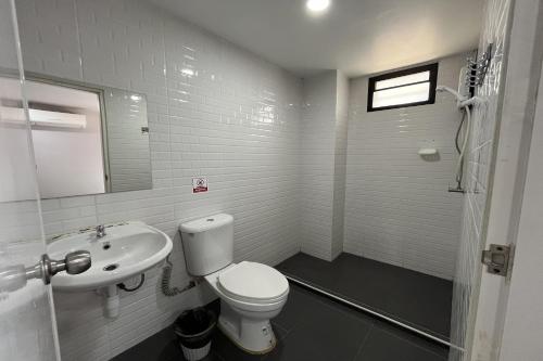 a white bathroom with a toilet and a sink at Blue26 in Ban Wat Sala Daeng