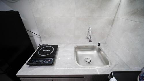 una encimera con fregadero y un teléfono. en Nice and Comfy Studio at Grand Dharmahusada Lagoon Apartment By Travelio, en Surabaya