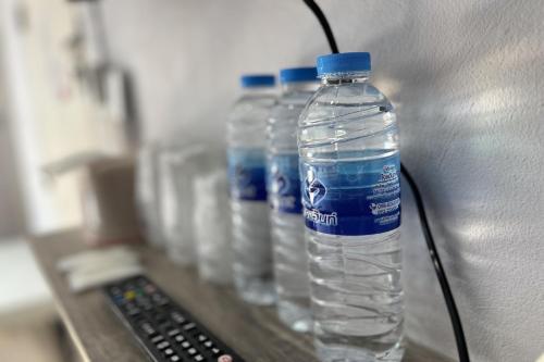 a row of bottles of water sitting on a shelf at Blue26 in Ban Wat Sala Daeng