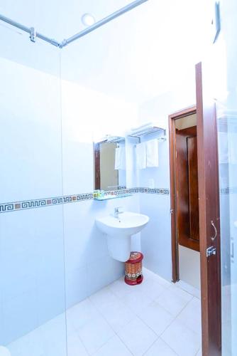 a white bathroom with a sink and a shower at Bong Sen Xanh Hotel in Cao Lãnh