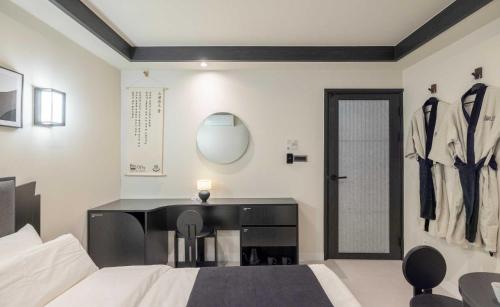 a bedroom with a desk and a bed and a mirror at Aank Hotel and Spa Jongno Unni in Seoul