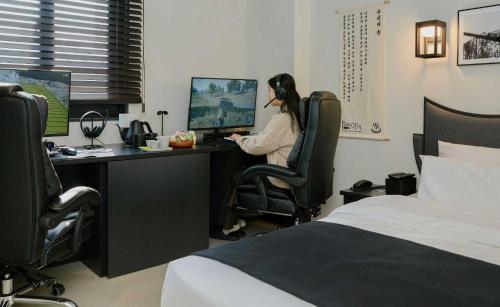 a woman sitting at a desk in front of a computer at Aank Hotel and Spa Jongno Unni in Seoul