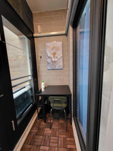 a small table and chair in a room with a window at Modern Chic in Hengchun
