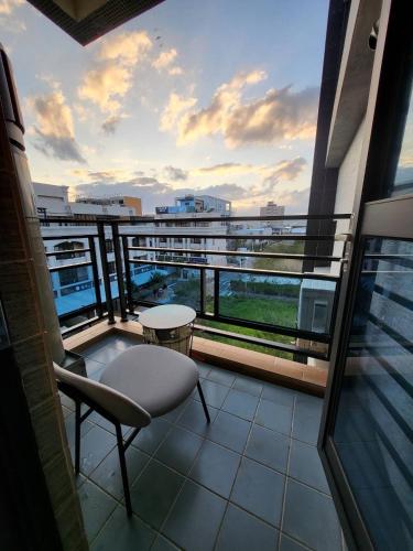 a balcony with a table and a chair on a building at Modern Chic in Hengchun