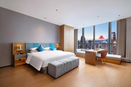 重慶市にあるPagoda Hotel Chongqing Jiefangbeiの大きなベッドと大きな窓のある寝室