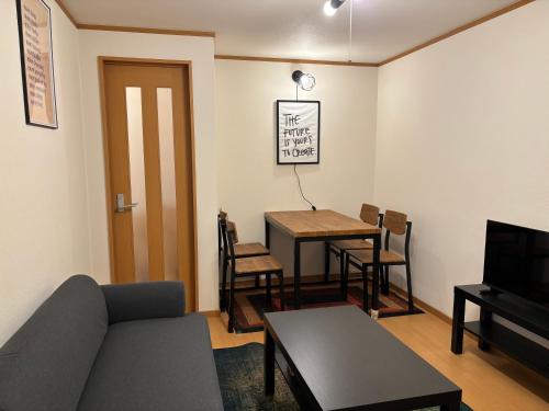 a living room with a couch and a table at 777 Takamatsu Guest House in Takamatsu