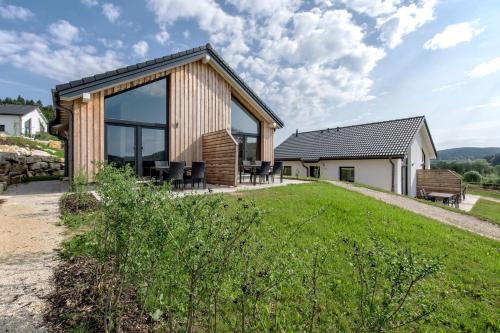 a house on a hill with a glass extension at Panoramabungalow DHH in Obernsees