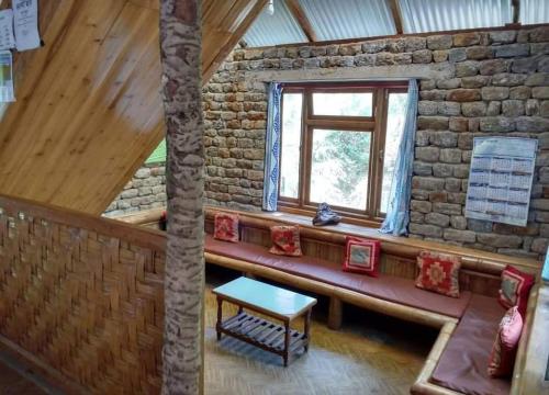 a room with a bench in a building with a window at Aranya Baas By StayApart in Sukhia Pokhari