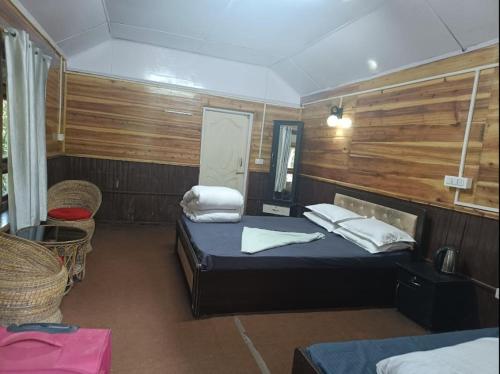 a bedroom with two beds and a table and chairs at Aranya Baas By StayApart in Sukhia Pokhari