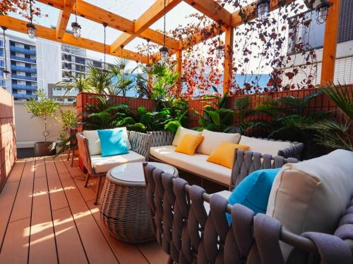 a patio with chairs and a couch on a roof at The GALA Hotel Umeda in Osaka