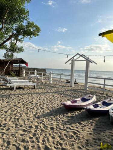 a beach with two boats on the sand at Sakâ Sakâ Beach House in Sipalay