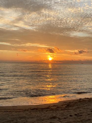 a sunset on the beach with the ocean at Sakâ Sakâ Beach House in Sipalay