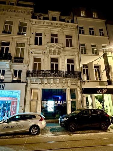 two cars parked on a street in front of a building at Luxury Suites Stay by Rikas Hotels in Antwerp