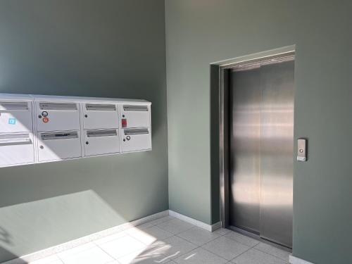 an empty room with a metal elevator and cabinets at Copenhagen City Luxe Retreat in Copenhagen