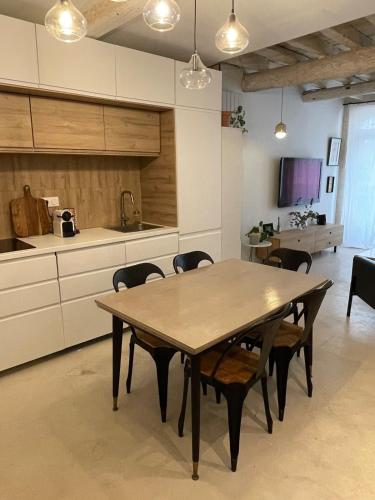 une cuisine et une salle à manger avec une table et des chaises dans l'établissement Maison quartier la Roquette, à Arles
