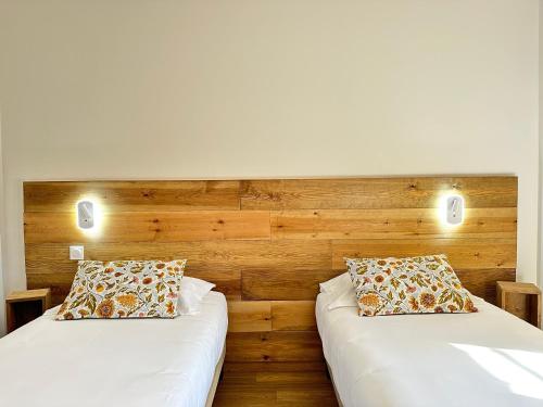 two beds sitting next to each other in a room at Hôtel Le Colombier in Moustiers-Sainte-Marie