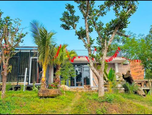 a house with palm trees in front of it at BIRD HOUSE villa in Hữu Biêt