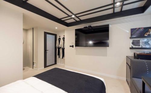 a bedroom with white walls and a black ceiling at Aank Hotel and Spa Jongno Unni in Seoul
