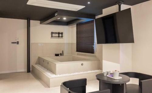 a bathroom with a tub and a table and chairs at Aank Hotel and Spa Jongno Unni in Seoul