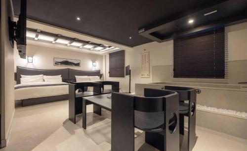 a bedroom with a bed and a table and chairs at Aank Hotel and Spa Jongno Unni in Seoul
