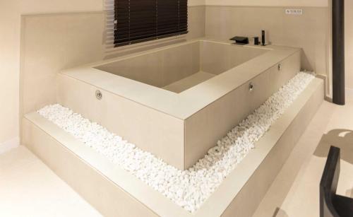 a white bath tub sitting in a room with a window at Aank Hotel and Spa Jongno Unni in Seoul