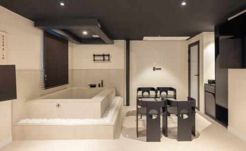a bathroom with a tub and two chairs and a table at Aank Hotel and Spa Jongno Unni in Seoul