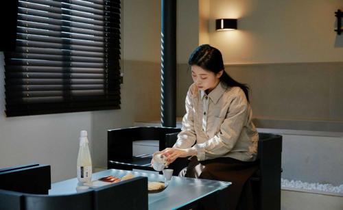 a woman sitting at a table with a plate of food at Aank Hotel and Spa Jongno Unni in Seoul