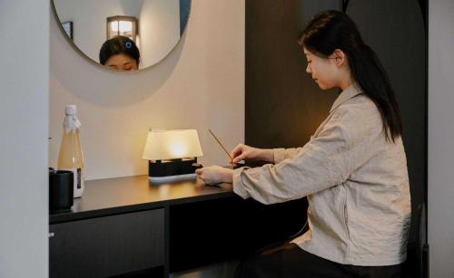 a woman sitting at a desk in a hotel room at Aank Hotel and Spa Jongno Unni in Seoul