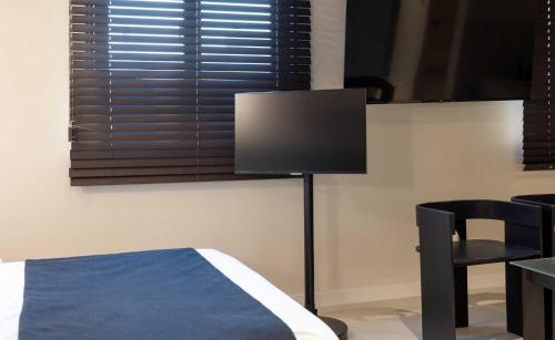 a bedroom with a tv and a table and a chair at Aank Hotel and Spa Jongno Unni in Seoul