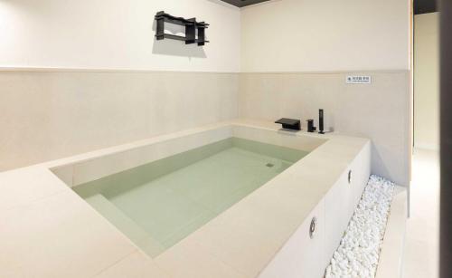 a large bath tub in a white bathroom at Aank Hotel and Spa Jongno Unni in Seoul