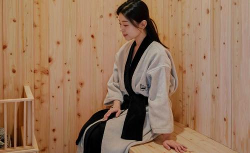 a woman in a kimono sitting in a room at Aank Hotel and Spa Jongno Unni in Seoul