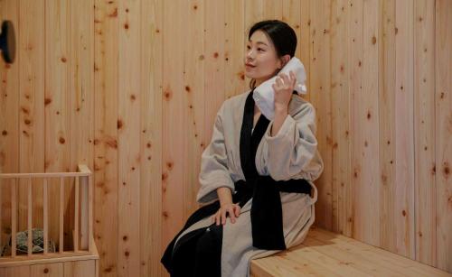 a woman in a kimono sitting in a room at Aank Hotel and Spa Jongno Unni in Seoul