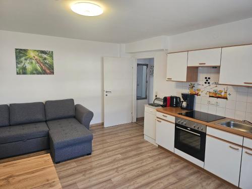 a living room with a couch and a kitchen at Ferienwohnung Melissa in Unter Feuchten