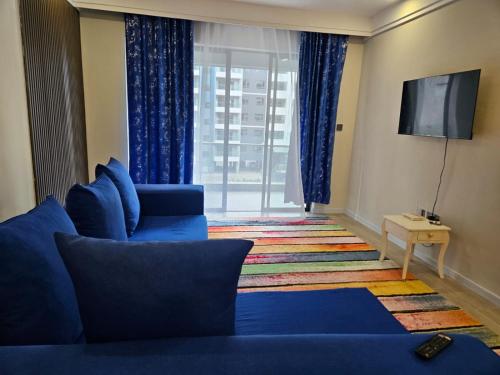 a living room with a blue couch and a sliding glass door at Ideal Homes, 3 Bedrooms in Nairobi