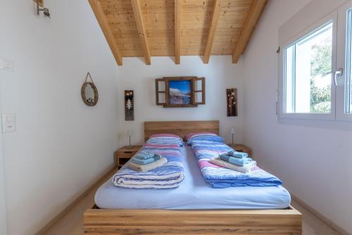 a bed in a room with towels on it at Tga Pilu a cozy and modern chalet on Savognin Ski Slopes with wonderful mountains view in Malmigiuer