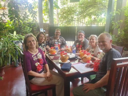 a group of people sitting around a table at Sri Lancashire Guest House in Bentota