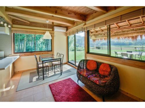 a living room with a couch and a table with chairs at Miyama KAYA Villa in Nantan city