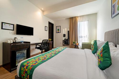 a hotel room with a large bed and a television at Treebo Premium The Mustard Inn Lawrence Road in Amritsar