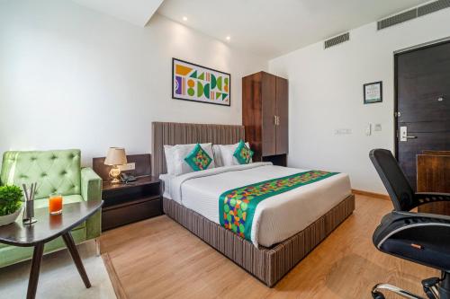 a bedroom with a bed and a desk and a chair at Treebo Premium The Mustard Inn Lawrence Road in Amritsar