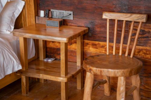 a wooden table and two chairs next to a bed at Celestial Valley in Zhangjiajie