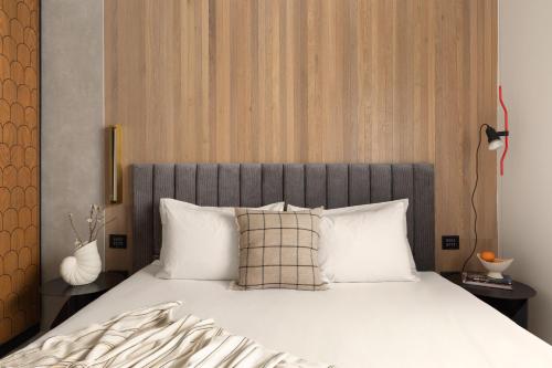 a bedroom with a large bed with white pillows at Hotel Bazaar - Fattal Colors in Tel Aviv