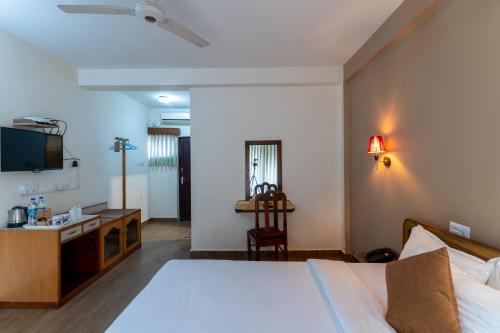 a bedroom with a bed and a desk and a television at Lake View Resort in Pokhara