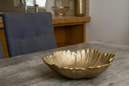 a gold bowl sitting on top of a table at ESCAPADA AL MAR Departamento el Rosarito in Rosarito Beach